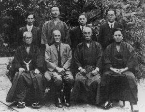 Otto degli uomini che votarono per il cambio di nome del karate nel suo moderno significato, Ottobre 25, 1936.da dietro,da sx a dx: Shinpan Shiroma, Tsuyoshi Chitose, Chosin Chibana, Genwa Nakasone. Avanti da sx a dx: Chotoku Kyan, Kentsu Yabu, Chomo Hanashiro, Chojun Miyagi. 